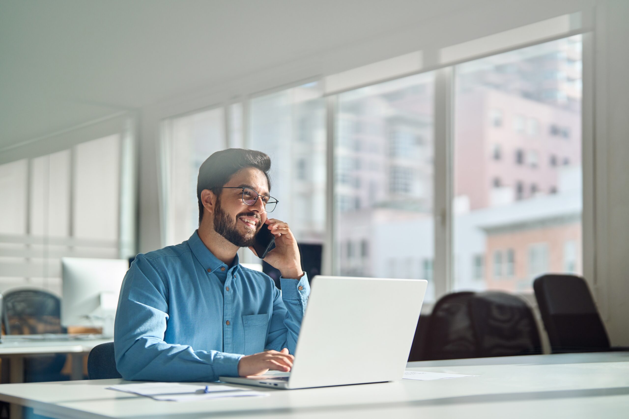 Young,Happy,Busy,Latin,Businessman,Talking,On,Phone,Using,Laptop
